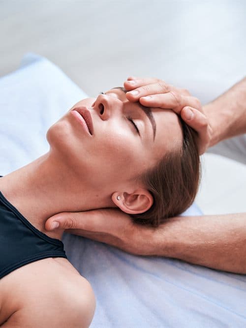 Fisioterapeuta aplicando un tratamiento de rehabilitación a un paciente en Tuisaúde, Tui